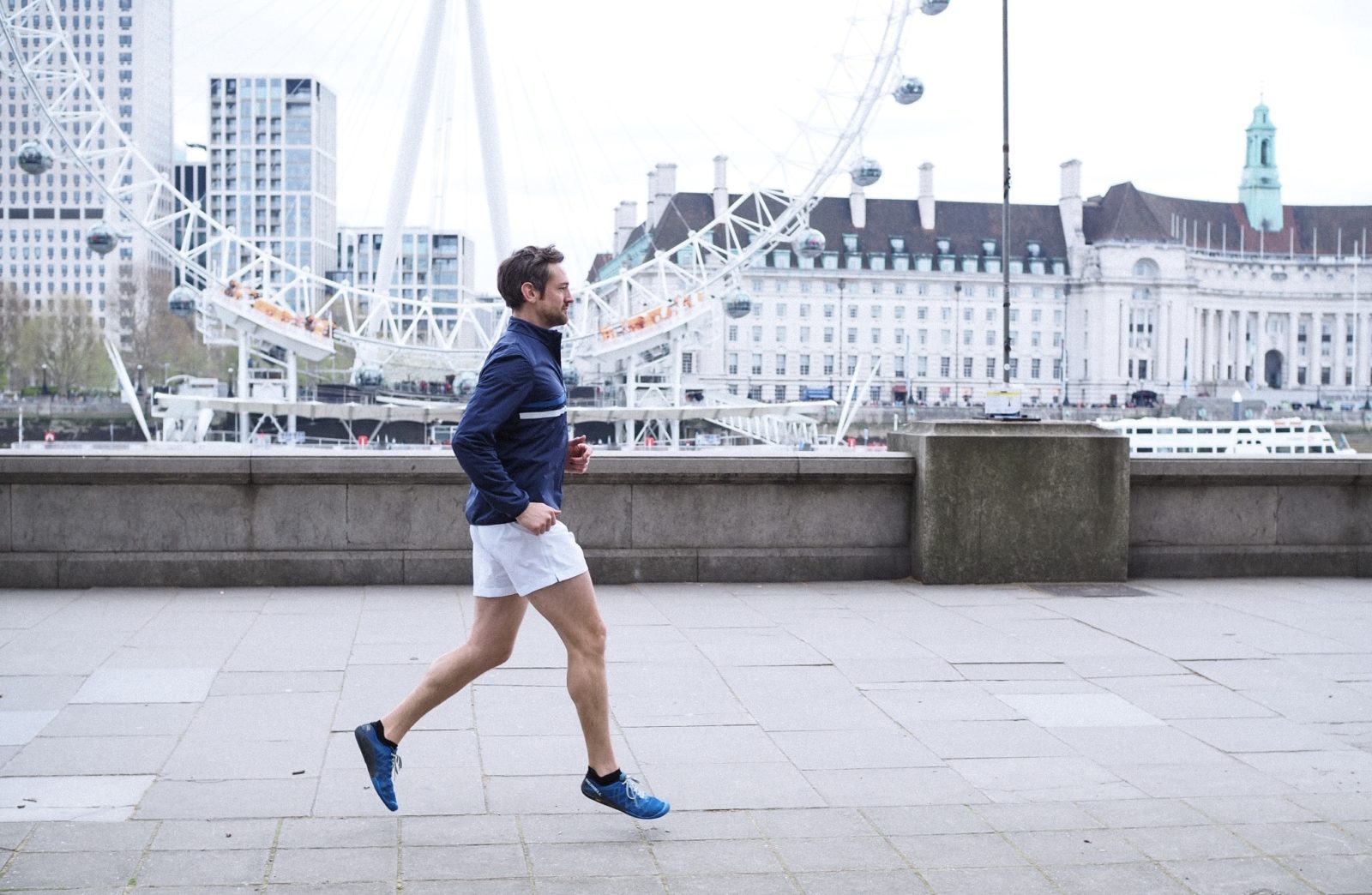 man running past london eye marathon